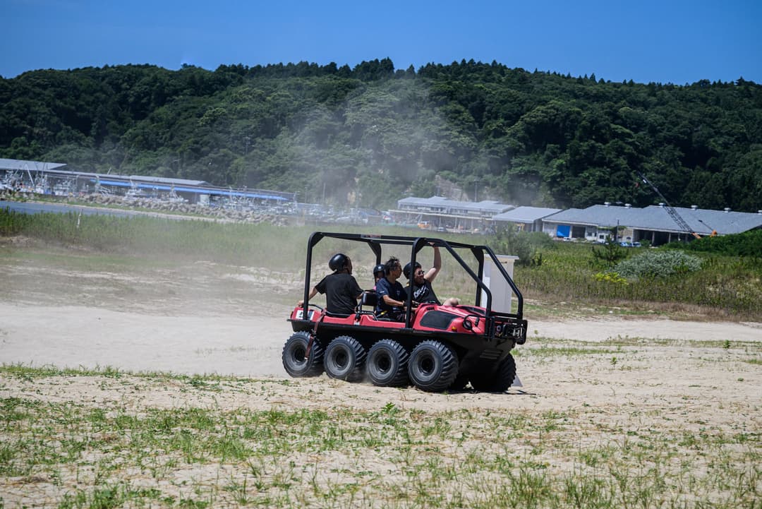 すごい勢いで砂浜を疾走する8バギーを楽しむ人々