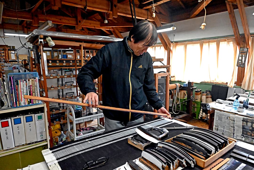 織った際に絣(かすり)の柄が出るように糸を染める作業は、緻密で高度な技術を要する