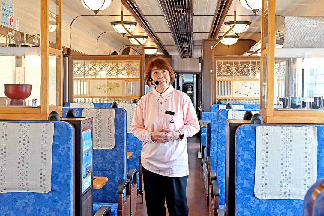 「のと里山里海号」で語り部をつとめる宮下左文さん。列車内の輪島塗、田鶴浜建具、珠洲焼、能登上布なども「この列車がどんな土地を走っているのか」を静かに物語っている