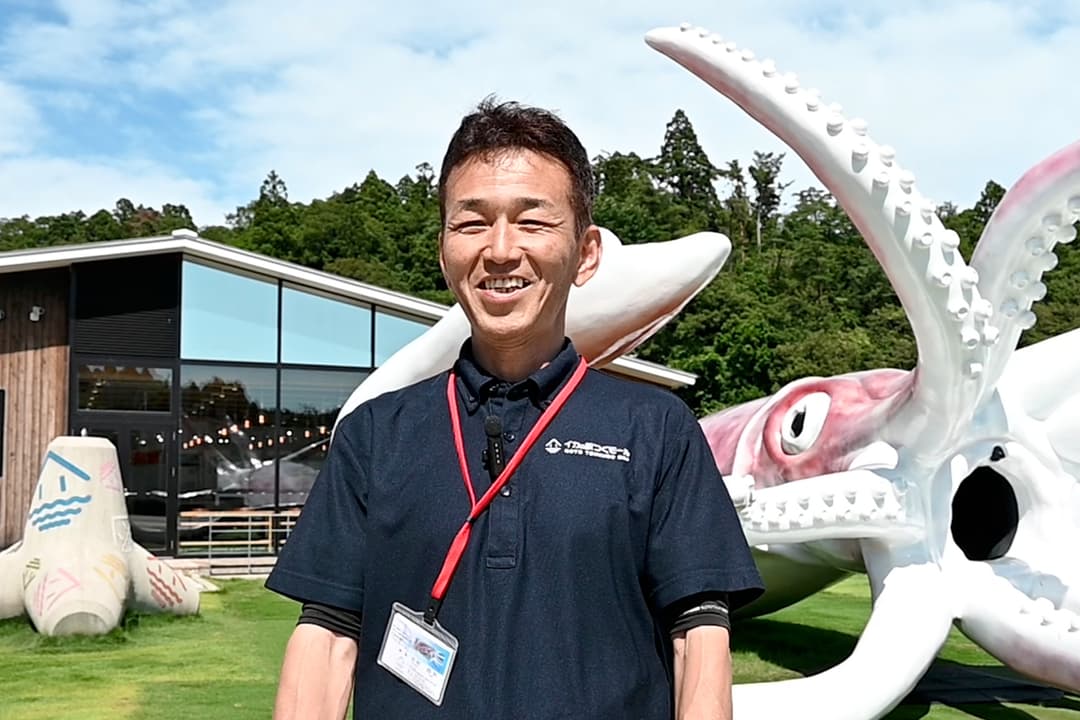 人気の撮影ポイントについて話す吉村さん。訪れた人は、イカキングの触手に巻き取られたり、口の中から顔を出したりと、ユニークな光景を撮影できる