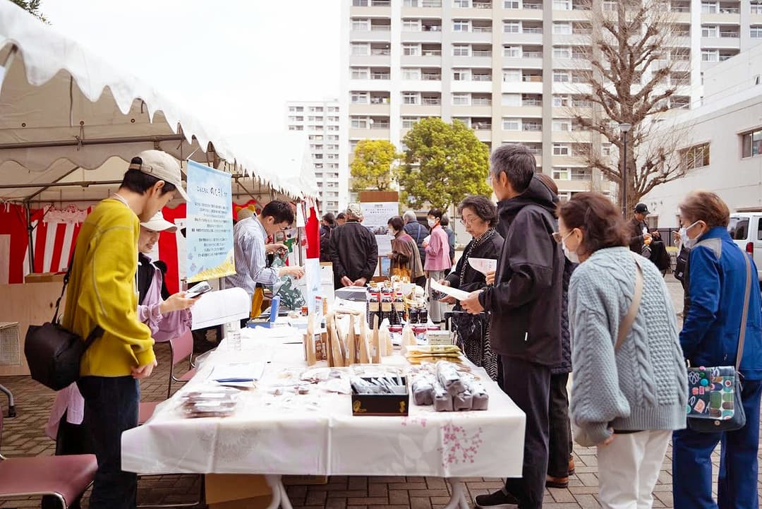 団地の自治会の協力のもと開催された「のと部 春まつり2026」。屋外に並んだテントでは能登の物産品販売やフードの提供も行われた(画像提供:のと部)