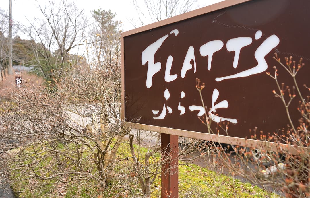 能登町矢波の道沿いに立つ“能登イタリアンと発酵食の宿 ふらっと”の看板。「FLATT」は船下さんの夫・ベンさんの苗字(撮影:2026年3月 関口威人)